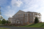 Apartment building exterior next to large boulder retaining wall